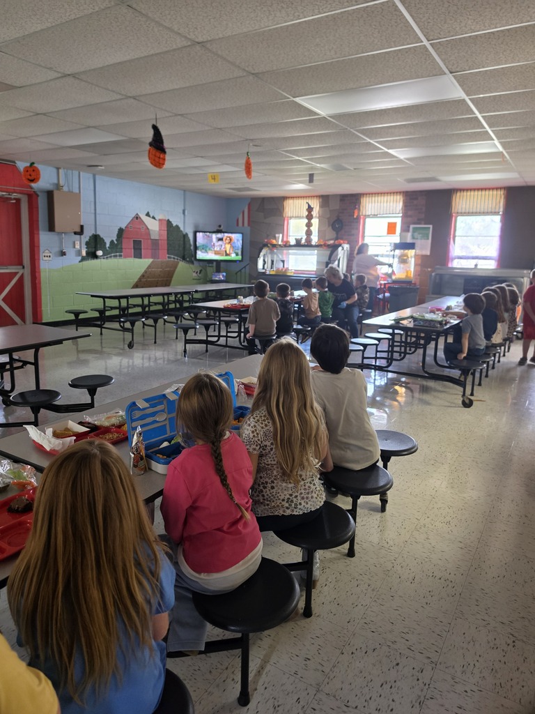 kids sitting at tables watching a movie