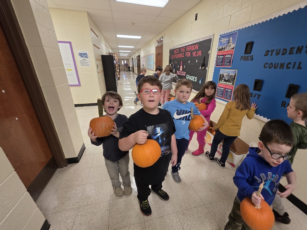 a group of students showing their pumpkins