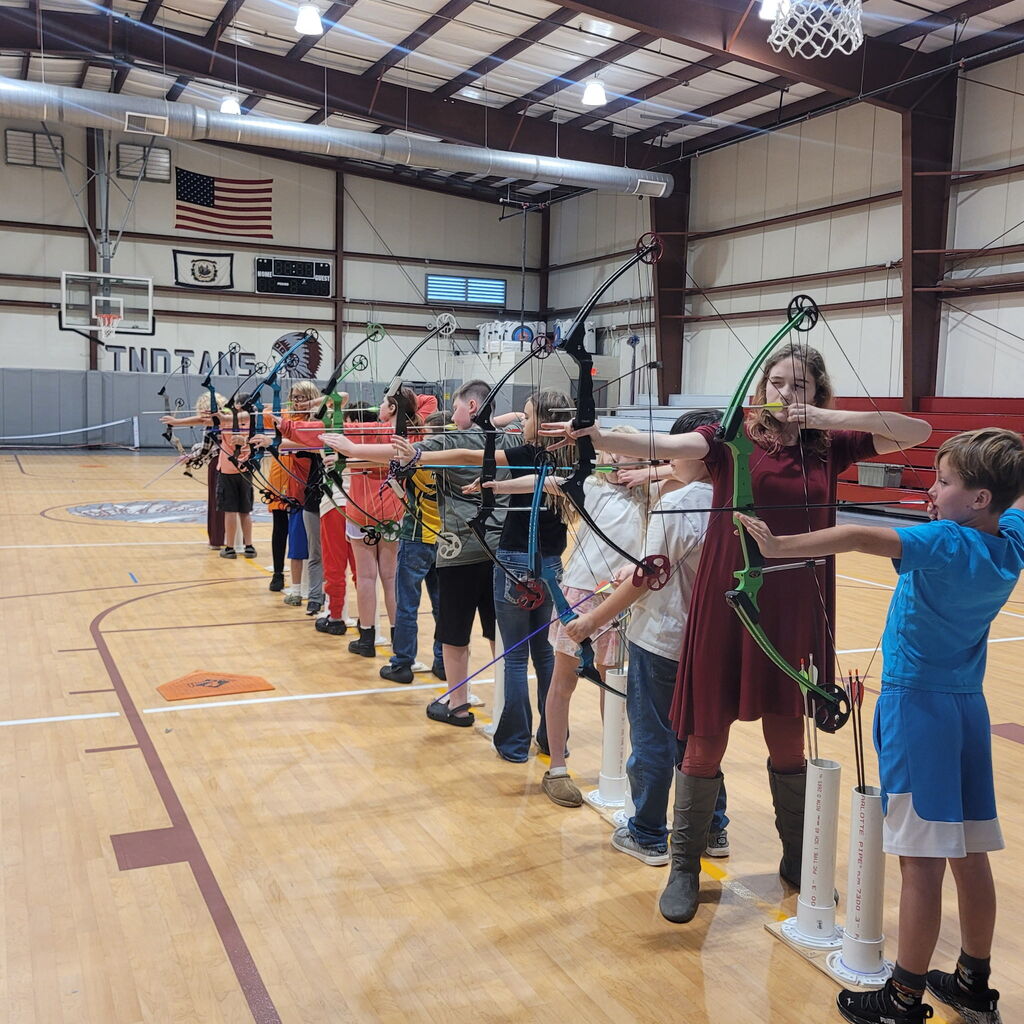 Archers standing in a line aiming at their targets.