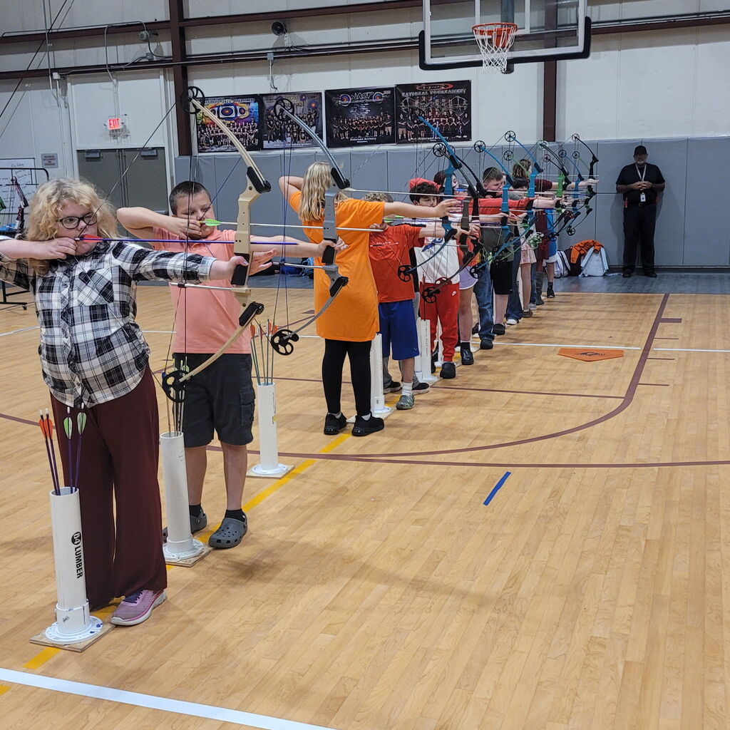 Archers standing in a line aiming at targets.