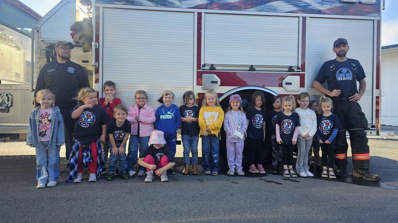 group of prek age students with firefighters at truck