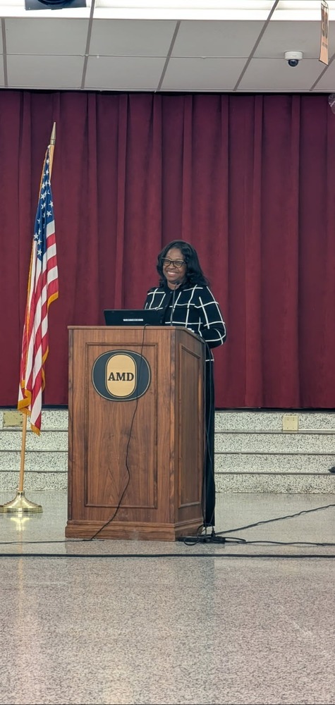 dr.white stands at a podium delivering a speech