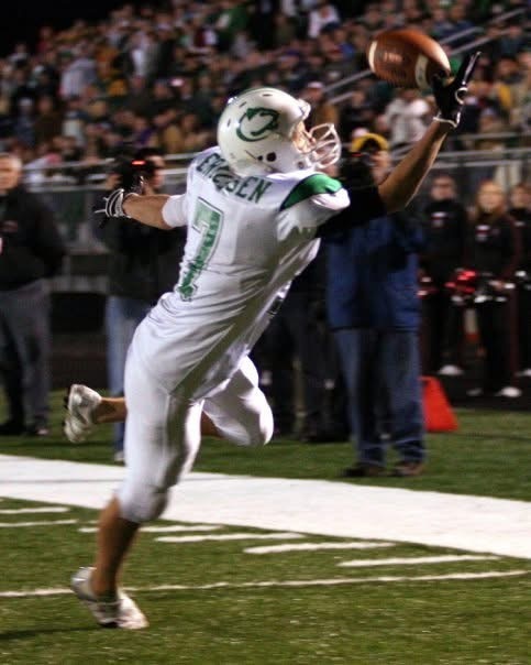 Football player reaching for a catch.