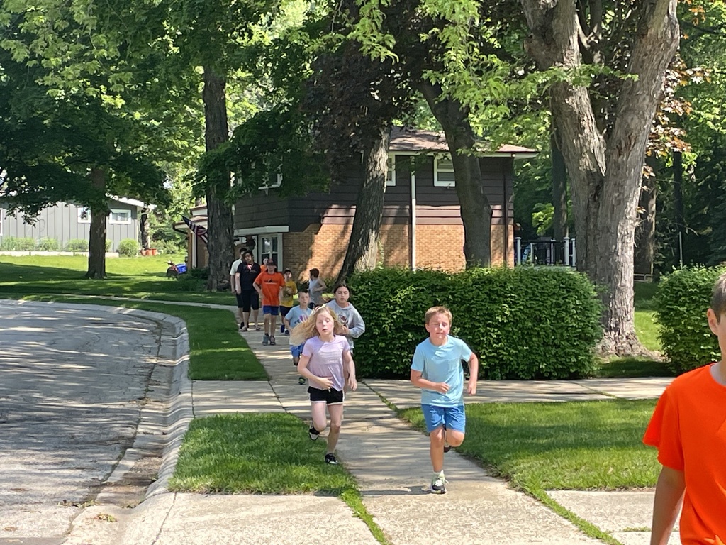 Students running through neighborhood.