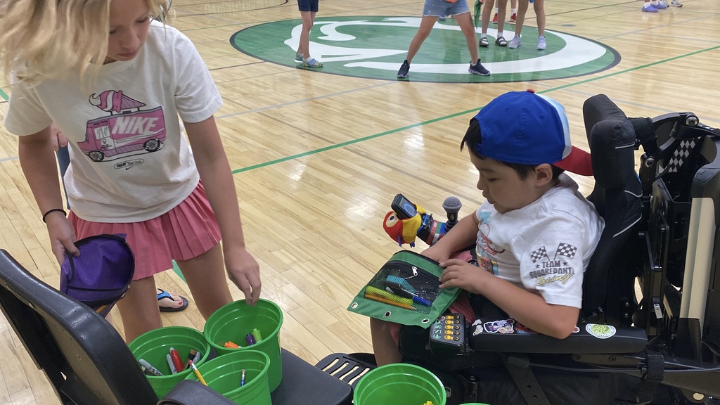 Kids filling a pencil case with supplies.