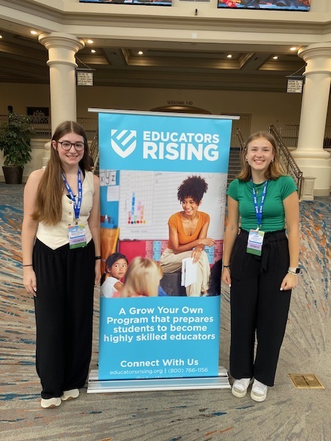 Two students standing with Educators Rising Banner