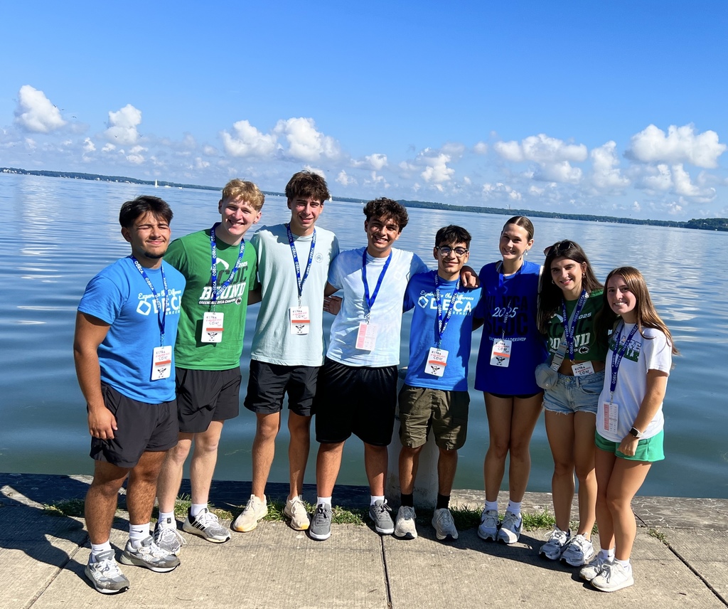 Eight students standing in front of Lake Mendota and smiling.