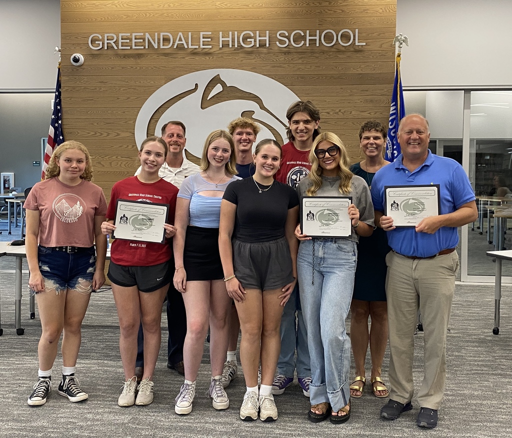 Students smiling holding certificates with three adults.