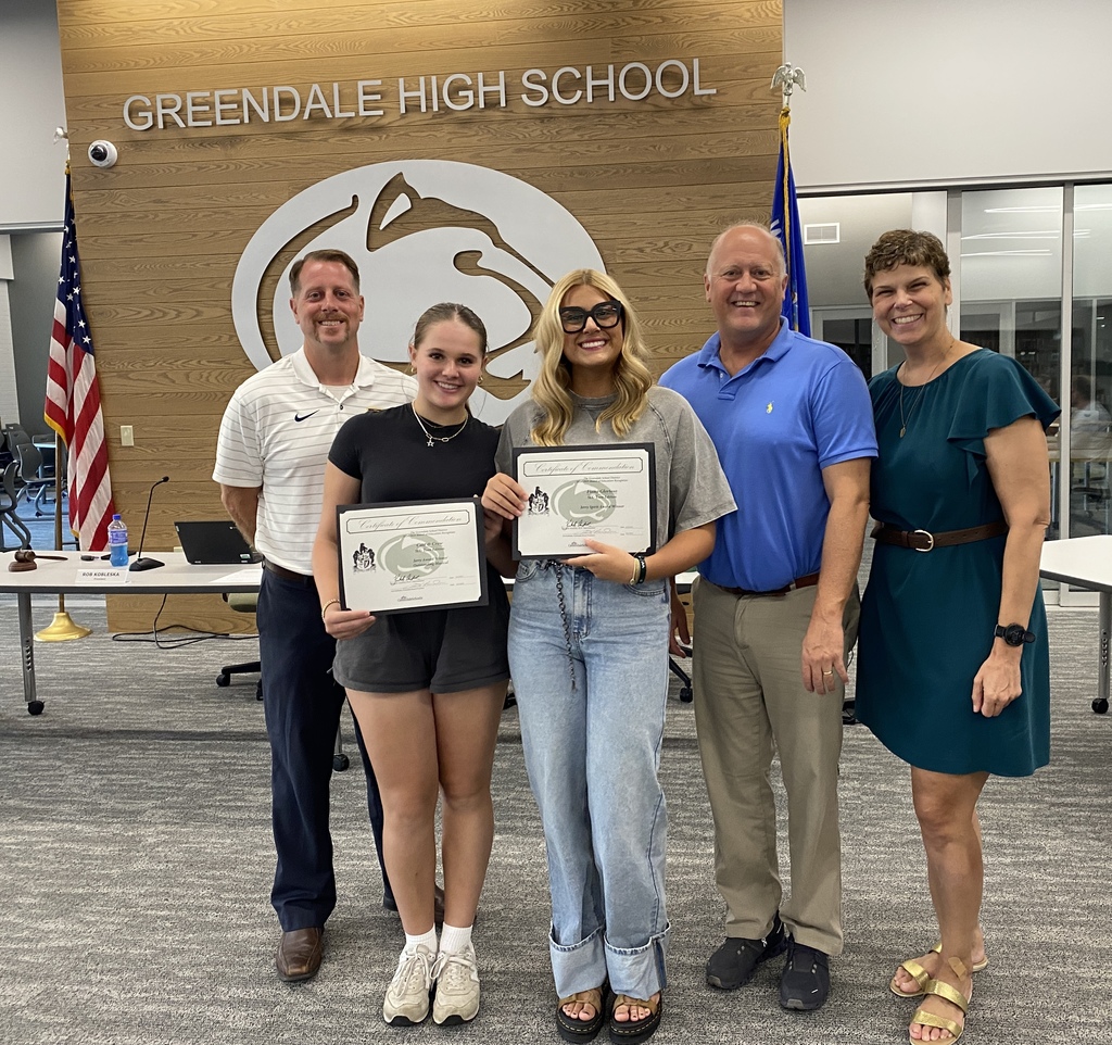Students smiling holding certificates with three adults.