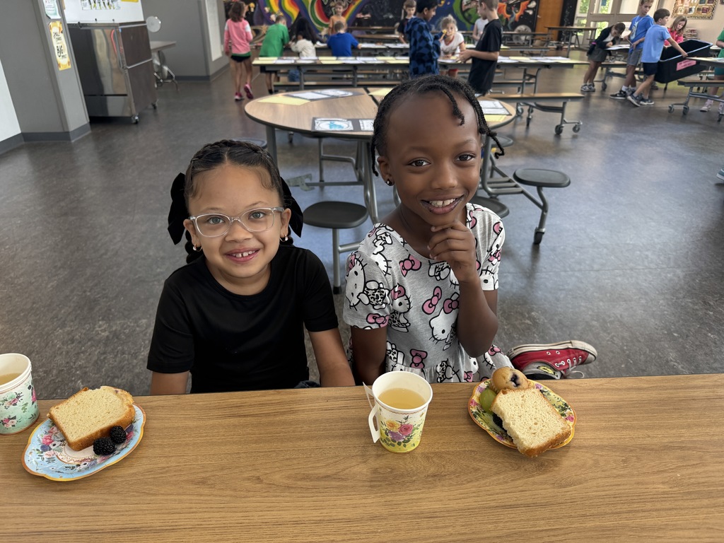 Students smiling at the camera during tea party at school
