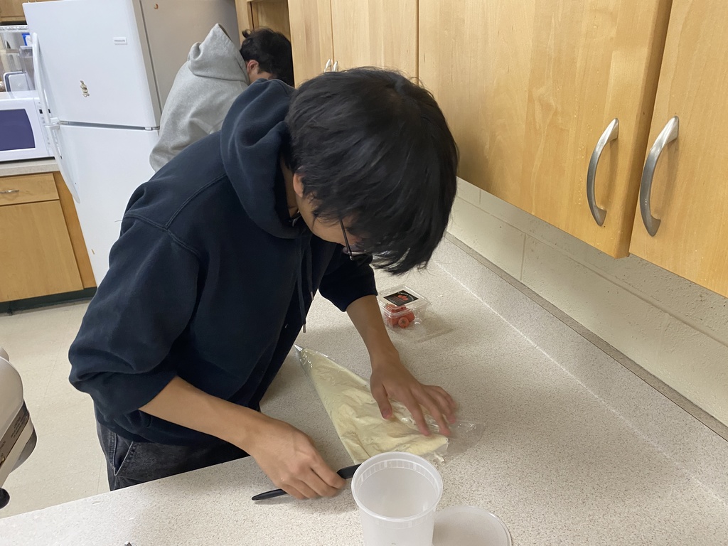 Student putfing frosting in the pastry bag