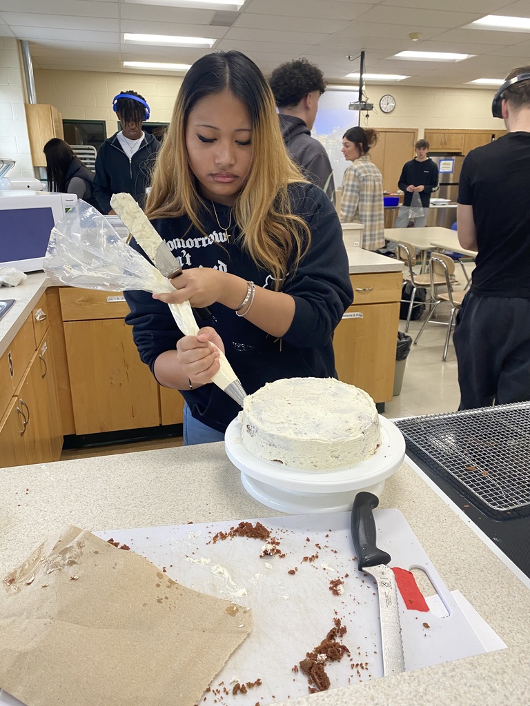 Piping frosting on a cake