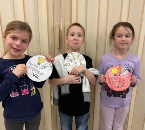 Students Holding Their Work After Learning About Perseverance