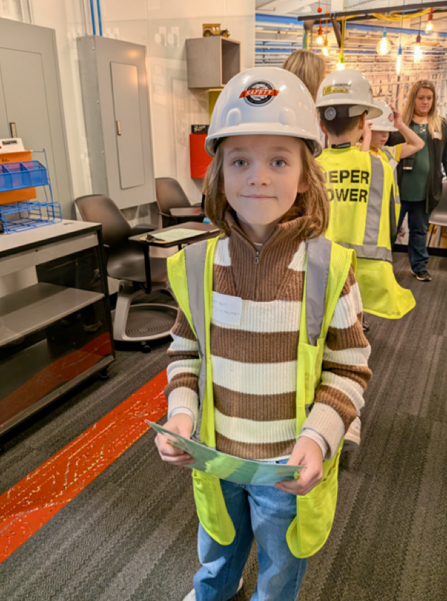 Student in hard hat and safety vest working a "job" in BizTown simulation