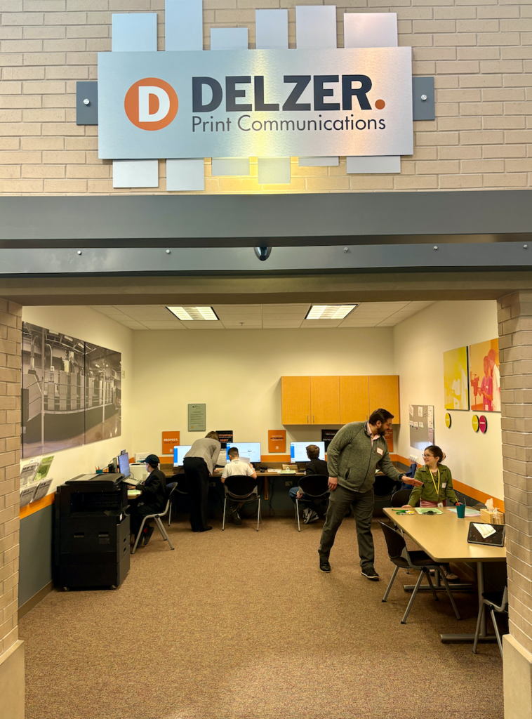 Adult supervisor overseeing students on computers working their "job" in BizTown simulation