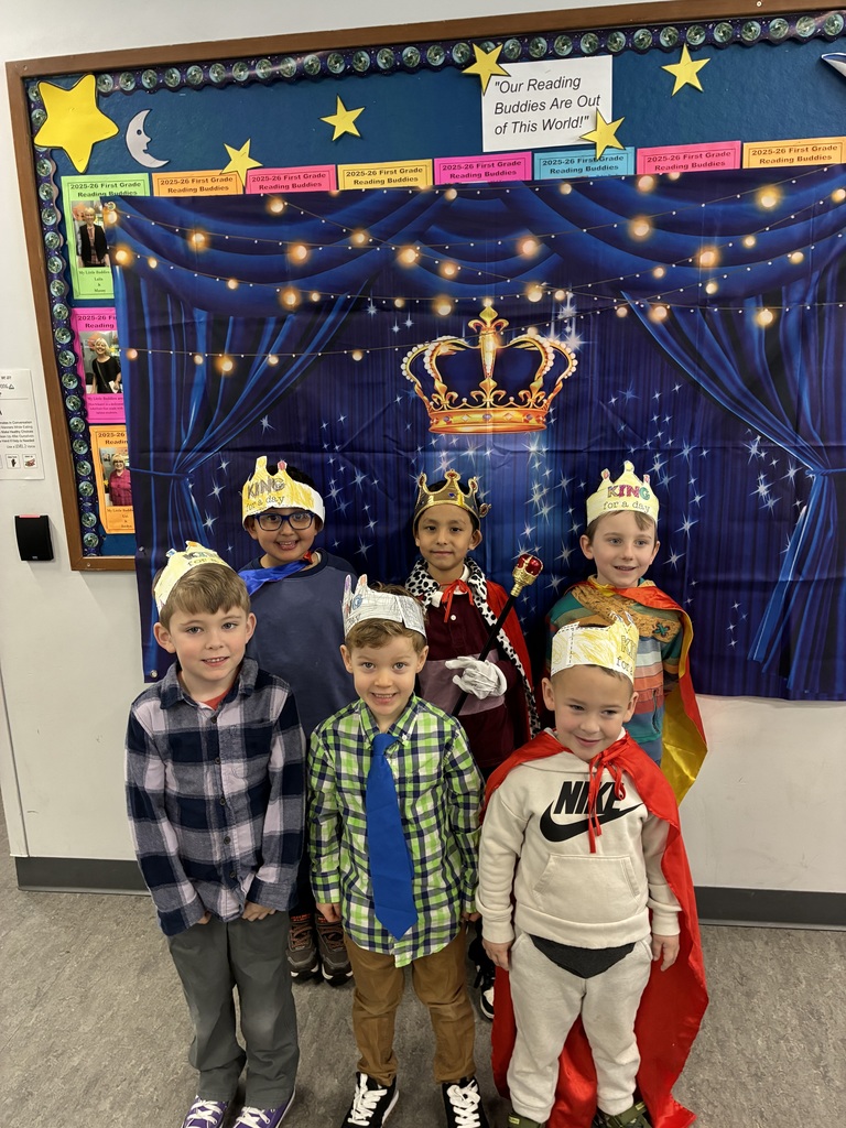 A group of boys dressed like royalty standing in front of a backdrop with a crown on it