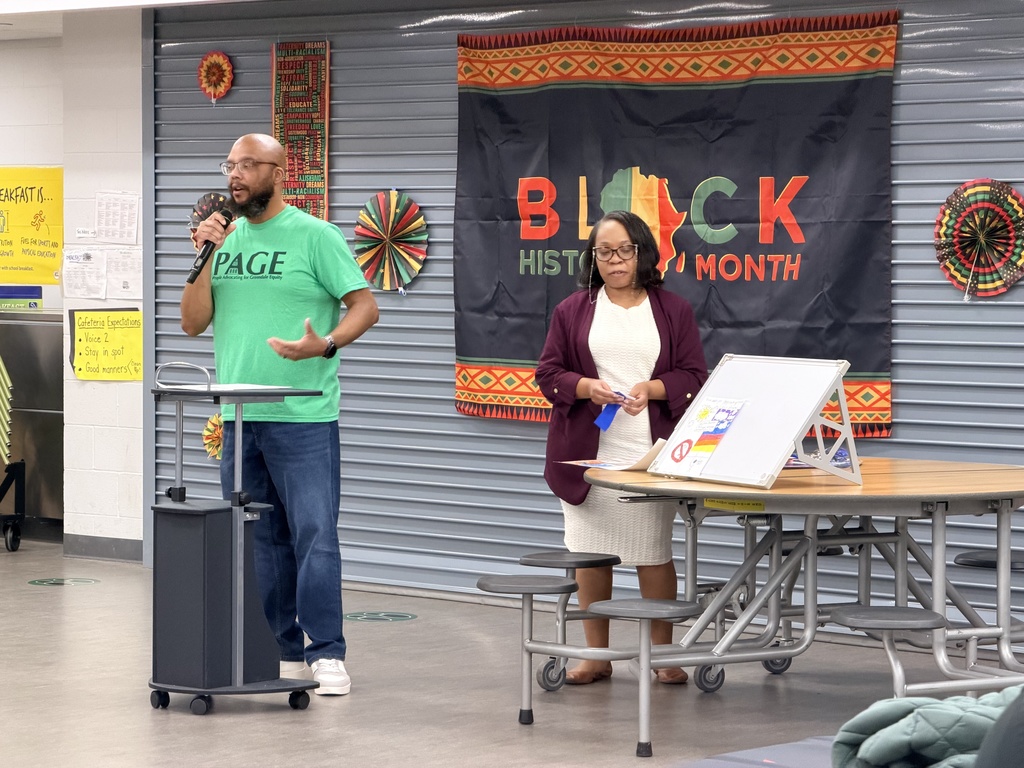 Adults explaining the awards they are giving for Black History Month