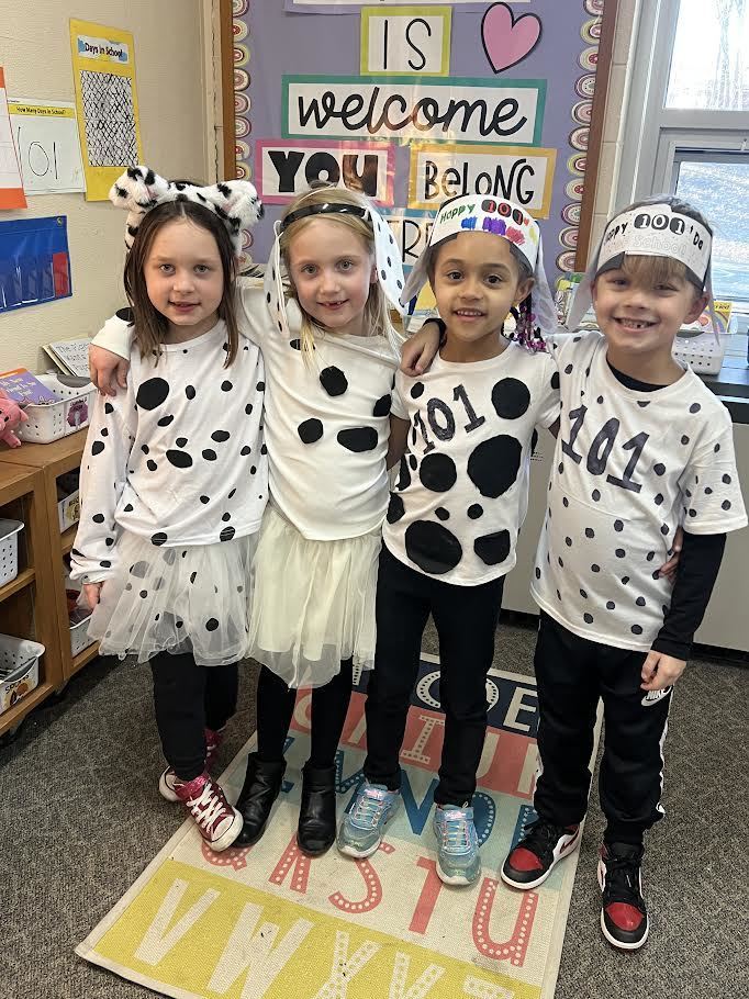 Four smiling students in dalmatian spirit wear celebrating 101 days of school.