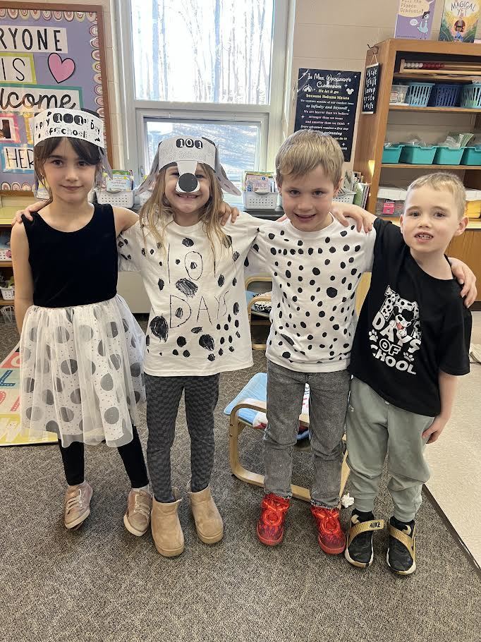 Four smiling students in dalmatian spirit wear celebrating 101 days of school.