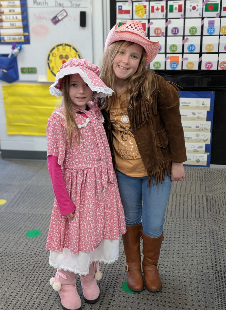 Two girls posing in Western apparel.