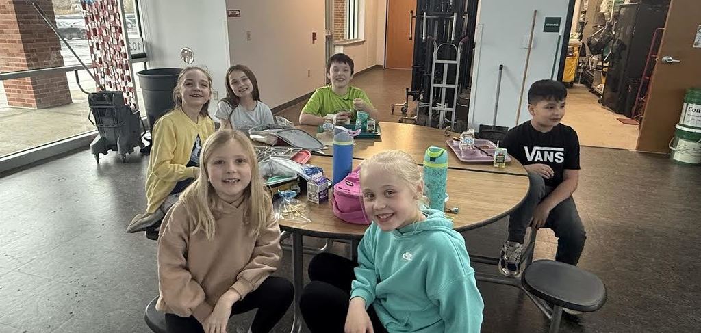 Smiling students at a lunch table during Glow reward lunch.