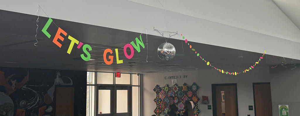 Fun banner in neon colors hanging in lunch room  that sasy "Let's Glow" at Glow reward lunch.