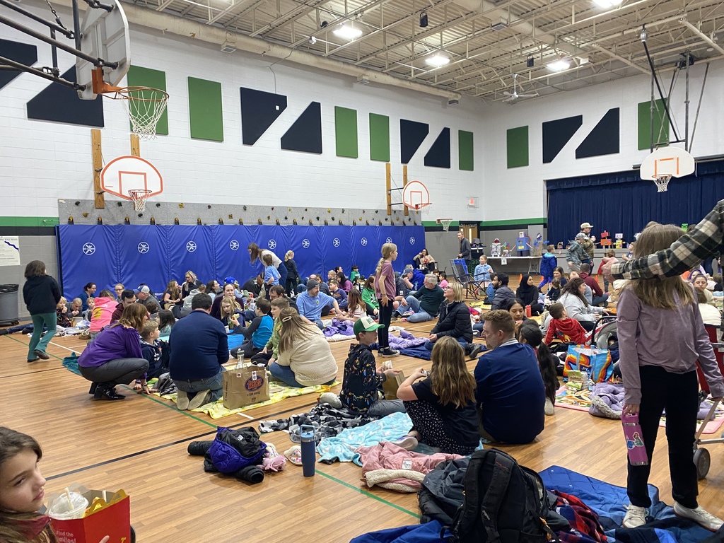 People in a gym having sitting and standing having a picnic