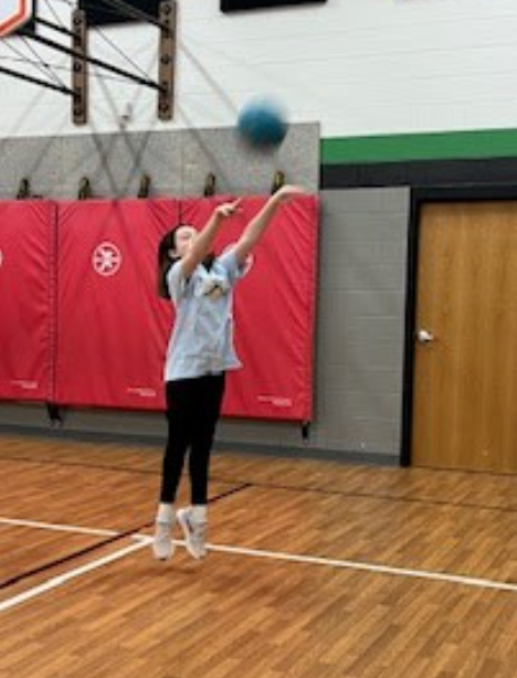 Girl shooting a basket.