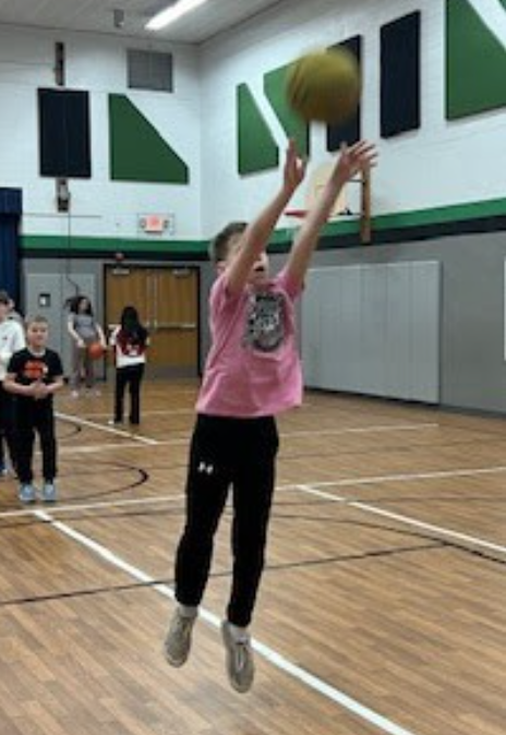 Boy jumping to shoot a basket.