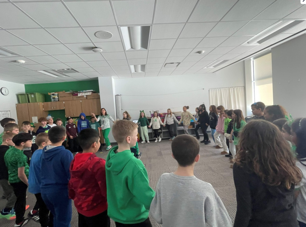 Fourth graders in a circle perform an Irish Folk Dance.