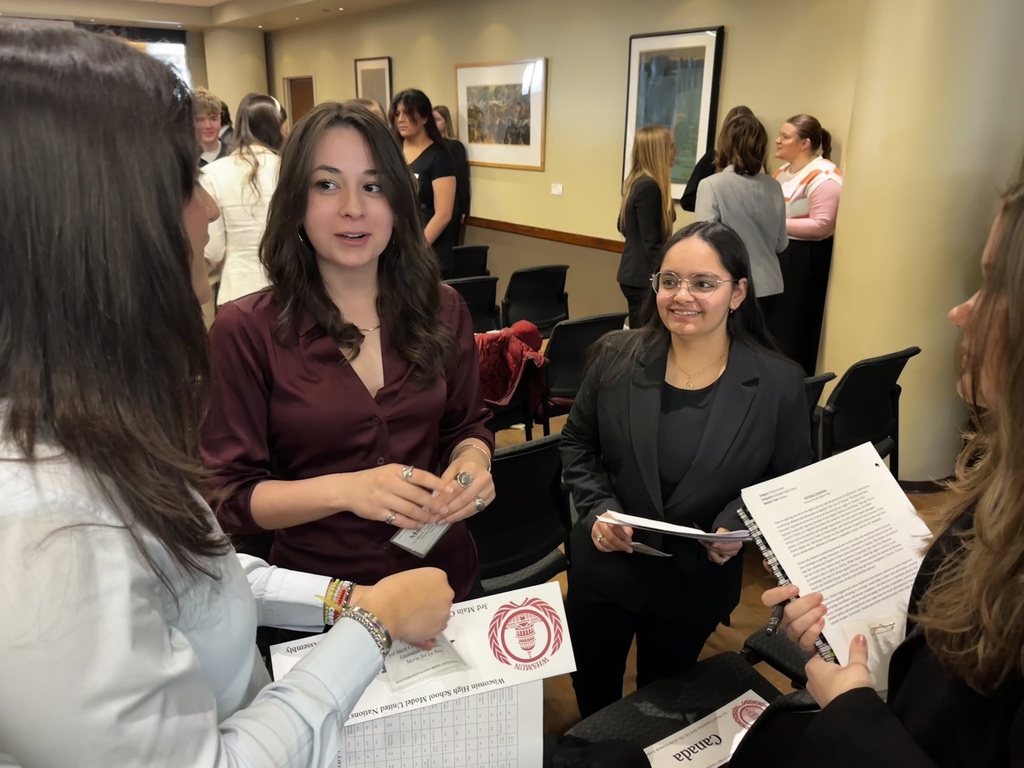 GHS students standing and talking with other students at Model UN conference.