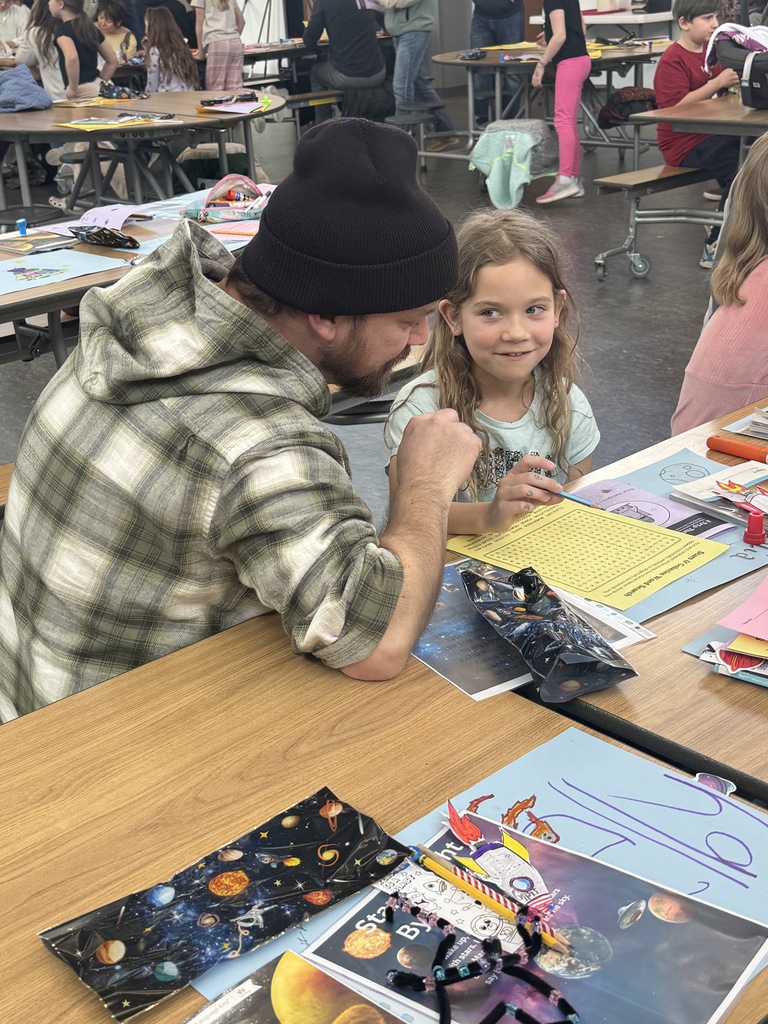 Third grader with family member demonstrating learning on Space.