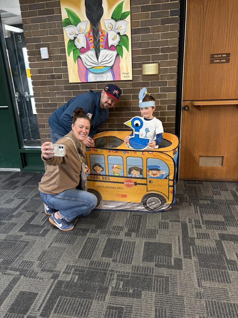 Pigeon Celebration: Two caring adults at photo booth with 5K student.