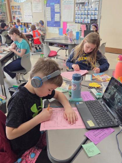 Astronomy: Third grade students doing research by reading and working on the computer.