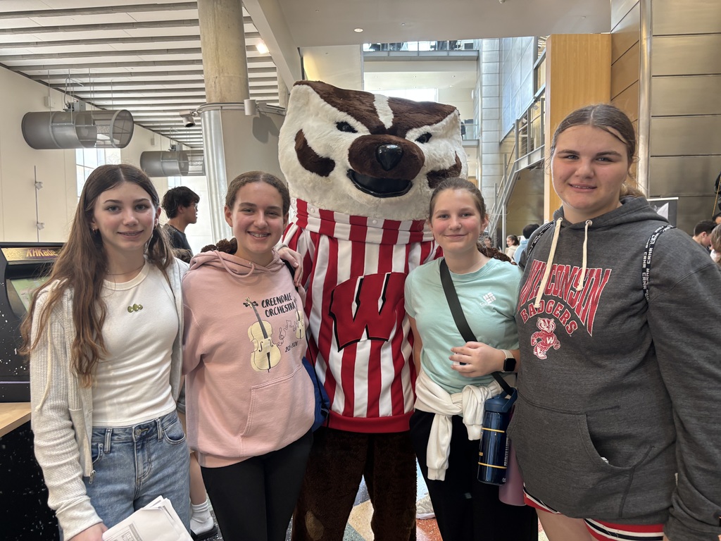 Students standing in college building with Bucky Badger Wisconsin Mascot