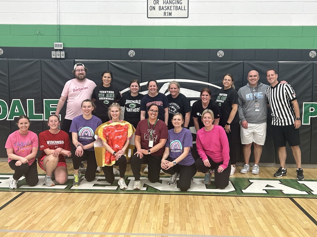 Staff posing as part of a basketball team  for a staff game as a reward for students' cooperation.