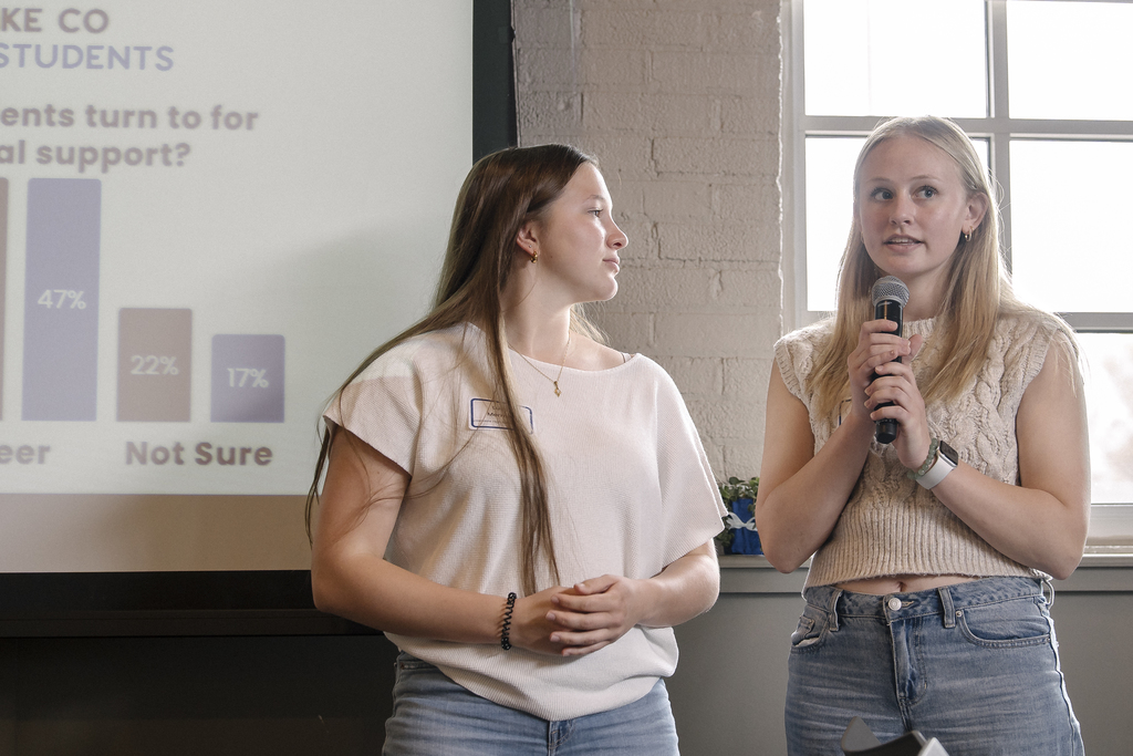 One person looking at the second person who is holding a microphone.
