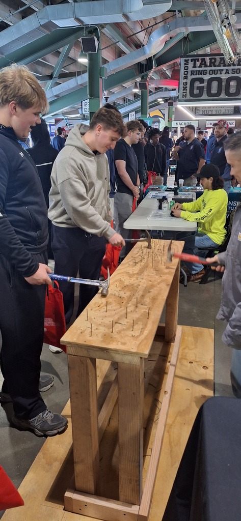 GHS students working with wood, hammer and nails at a trades career fair.