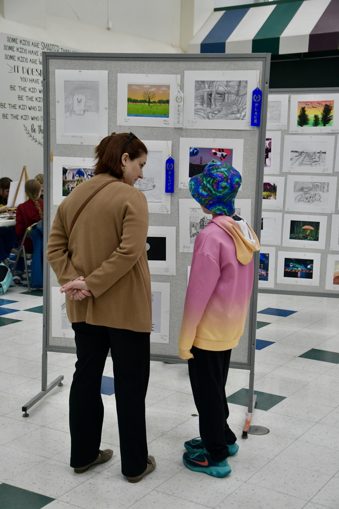 A parent and student checking out an art display at Gallery Night.