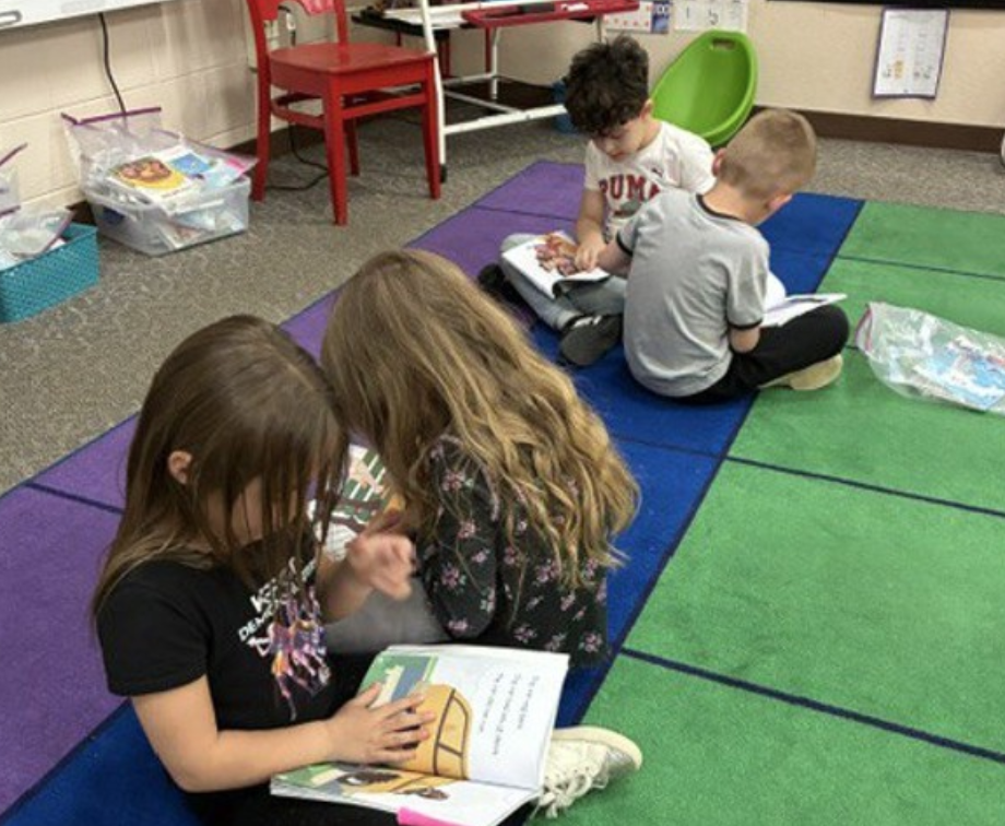 Two pairs of 5K students working on reading skills.