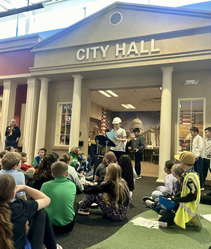 Students gathered at the City Hall listening to a speaker at the Biztown field trip.