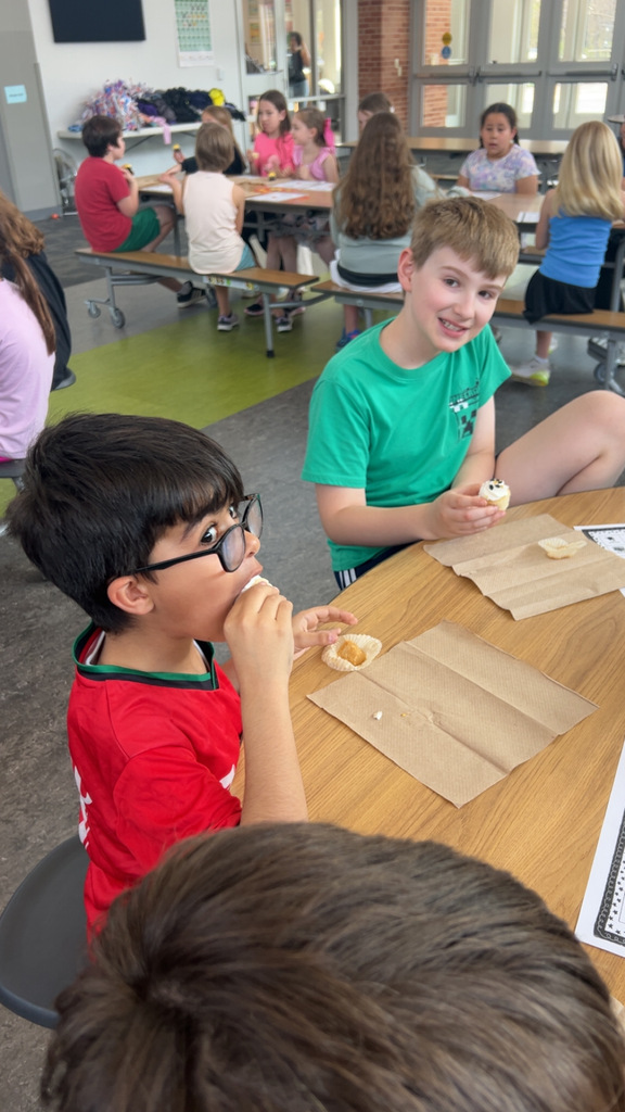 Students at tables eating Happy Birthday America cupcakes.