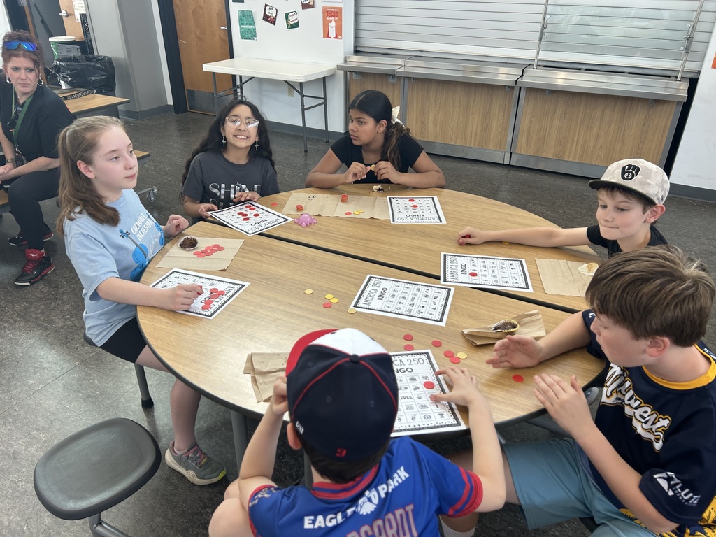 Students at tables playing America BINGO.