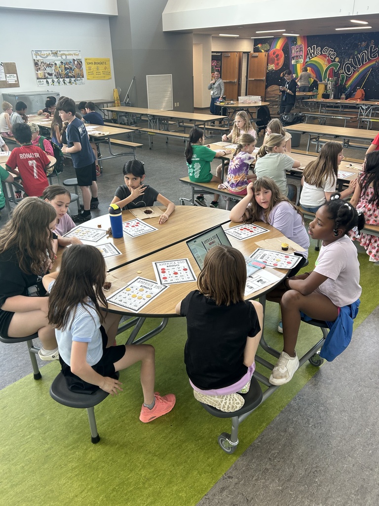 Students at tables playing America BINGO.