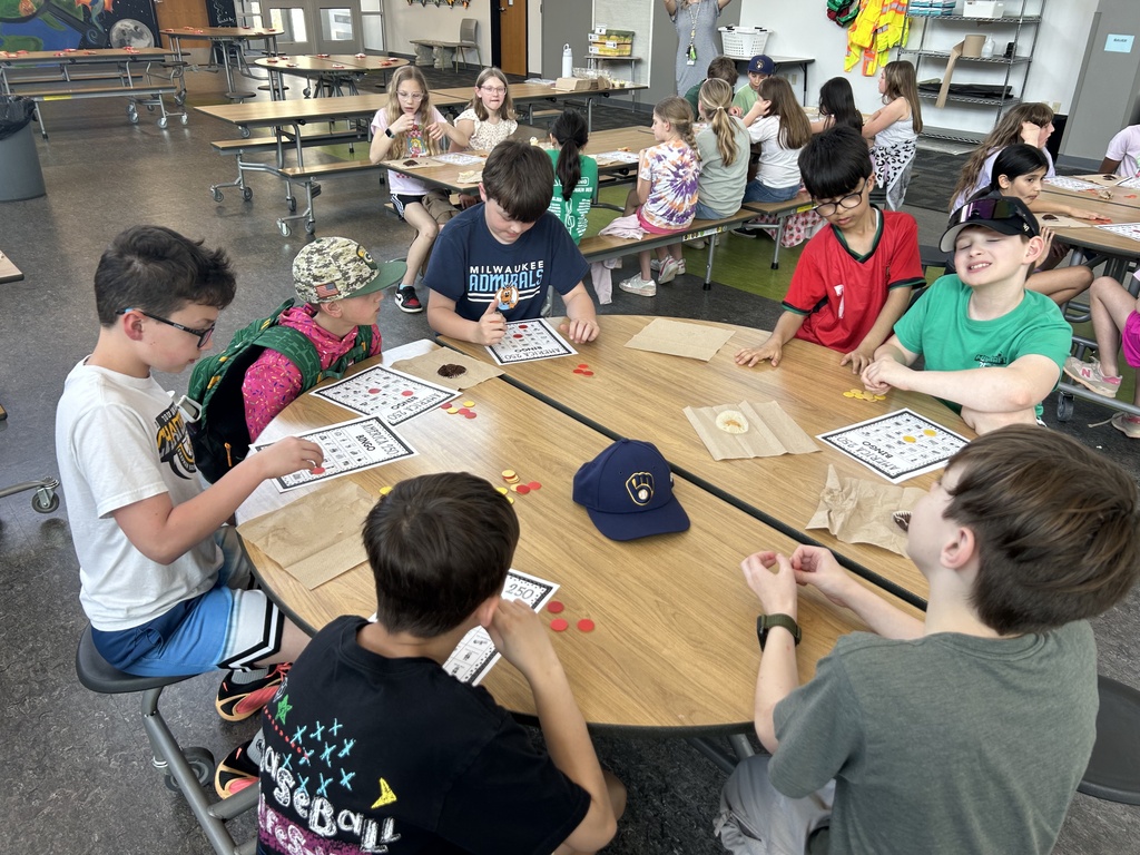 Students at tables playing America BINGO.