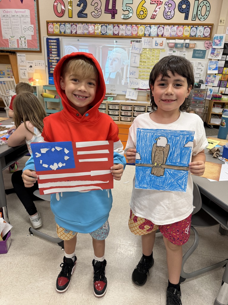 Two students smiling holding their Americana art work.