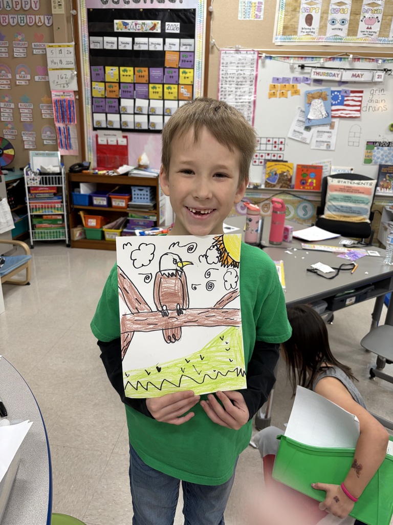 Student smiling and showing a portrait of an American Eagle