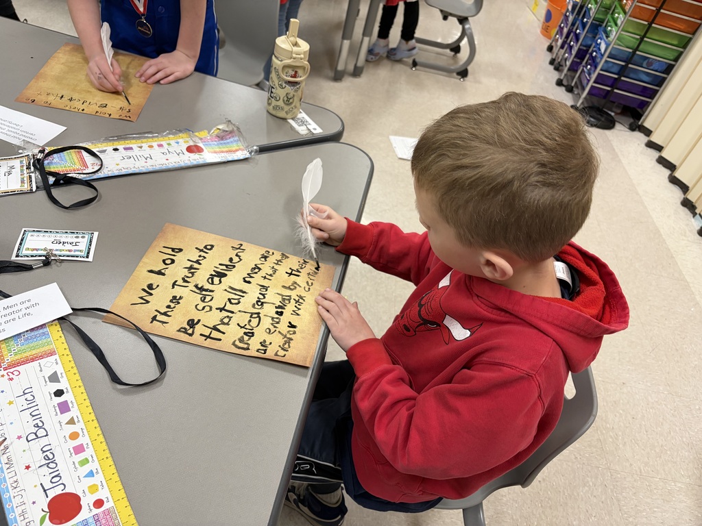 Student writing with a quill on parchment paper