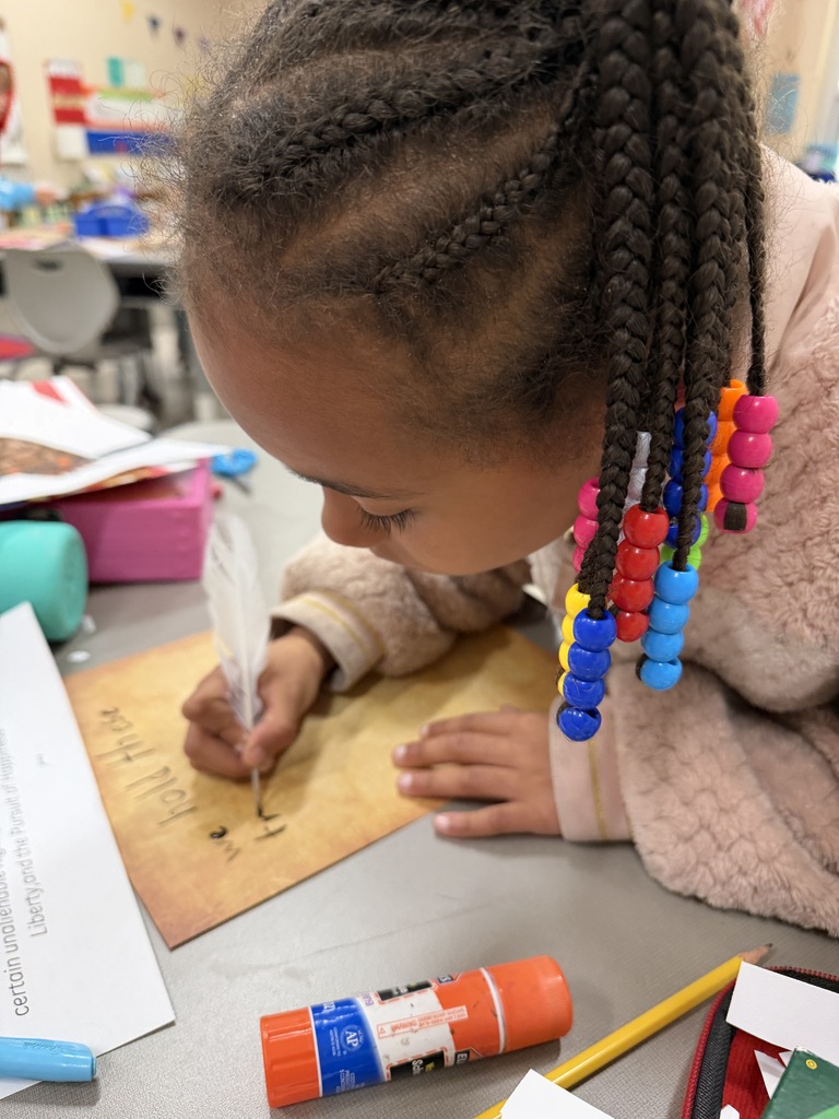 Student writing with a quill on parchment paper
