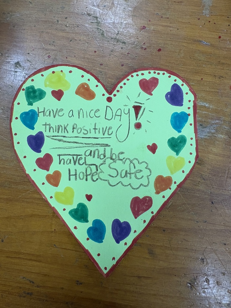 A heart-shaped paper with a message to be safe, think positive, and have a great day.